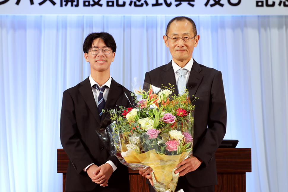 写真:学生と花束を持つ山中氏
