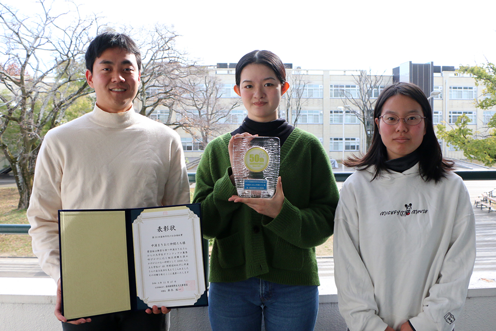 写真:表彰状と受賞盾を持つメンバー3人